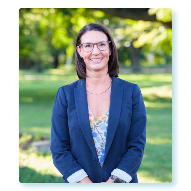 Jennifer Leeper smiling in a navy blazer at a Fairfield park